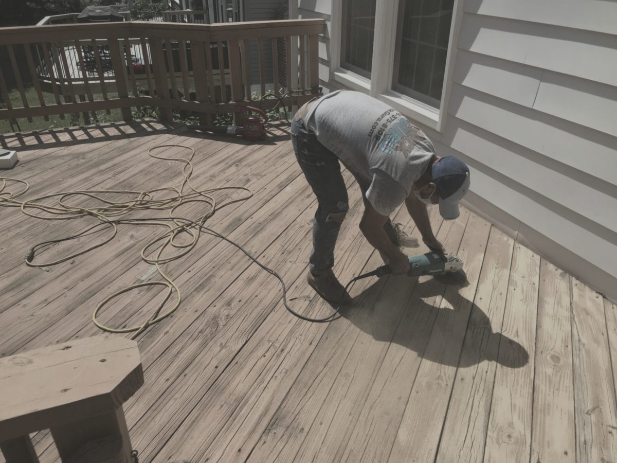 Deck before restoration: weathered, faded, grey timber
